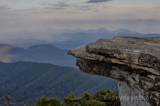 The popular ledge at McAfee Knob seen with ghost like mountains pushing through the clouds in the background.  In the left of frame is what I believe to be Amsterdam/Troutville, VA.